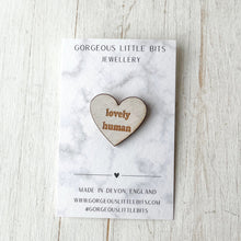 Load image into Gallery viewer, Heart-shaped wooden brooch with 'lovely human' text on a marble card with branding information.