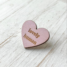 Load image into Gallery viewer, Heart-shaped wooden pin with 'lovely human' text on a light wooden surface