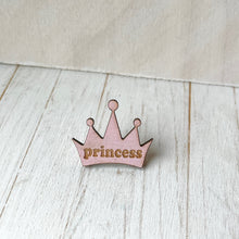 Load image into Gallery viewer, Pink crown-shaped pin with 'princess' text on a light wooden surface