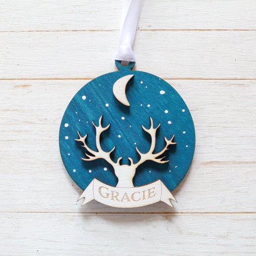 Decorative ornament with deer stag antler design and personalised text on a wooden surface