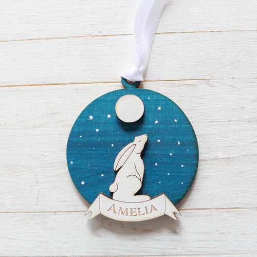 Decorative ornament with a white moon hare silhouette and personalised text on a blue background